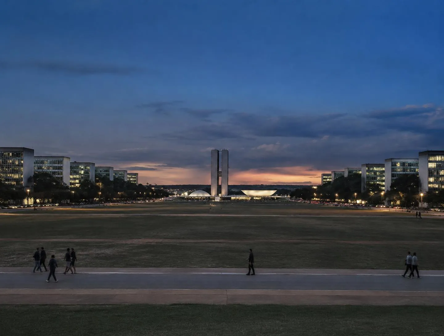 Esplanada dos Ministérios, em Brasília, ao anoitecer, com os prédios dos ministérios e o Congresso Nacional ao fundo